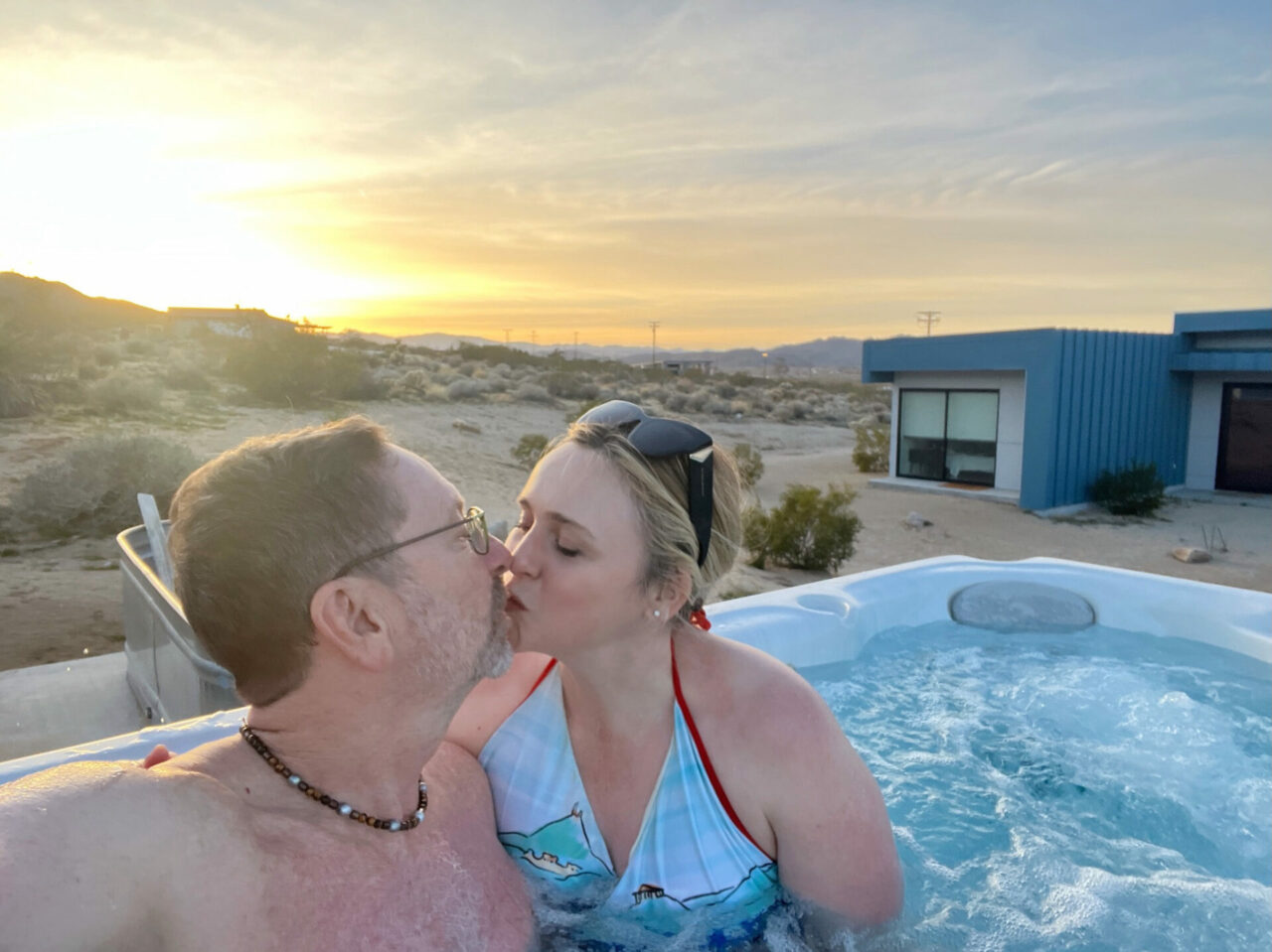 Dany & Eric in the hot tub kissing as the sun goes down in Joshua Tree